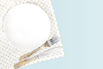 Empty plate, fork and knife on white background