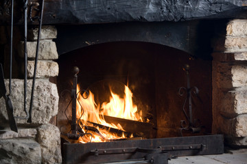 The burning fire in the fireplace warms the whole environment.