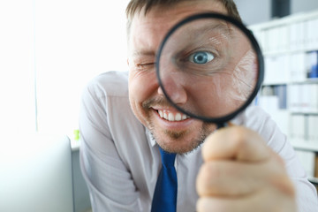Smiling businessman hold magnifying glass in hand. Where to invest profit search concept