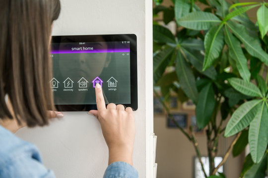 Young woman with tablet with smart home control functions