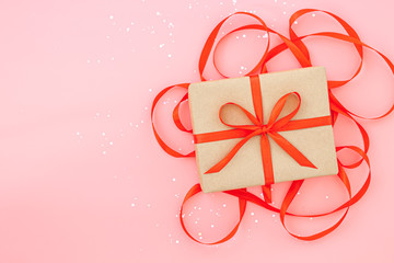 Isolated present or gift box in craft paper with red ribbon bow