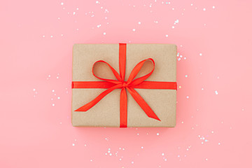 Isolated present or gift box in craft paper with red ribbon bow
