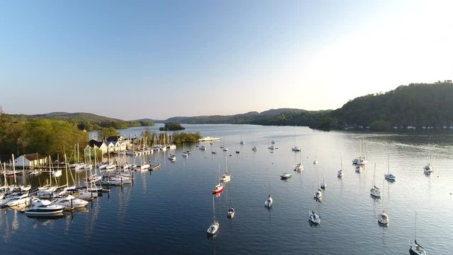 4K Fishing boats on Scottish lake in the highlands. Moored boats on still water with blue sky in a British summer tourist nature landscape
