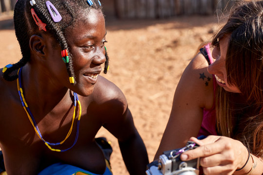 White woman showing a picture on her camera to a Mudimba tribe woman, Canhimei, Angola