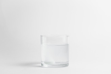 The effervescent tablet dissolves in a glass of water. Liquid medicine isolated on white background. Treatment of viral diseases. Help with depression and insomnia. Drink liquid multivitamins