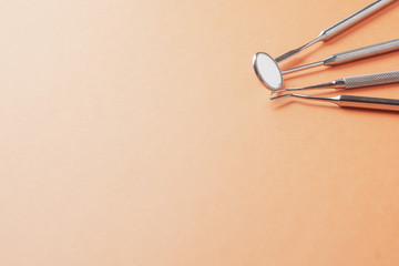 Metal dental tools, mirror, on an orange background