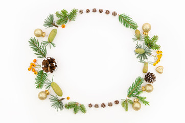 2020 Christmas circle floral composition. Wreath of green fur branches, larch cones, Christmas glass balls and berries. White table background. Flatlay with copy space for greeting text or lettering