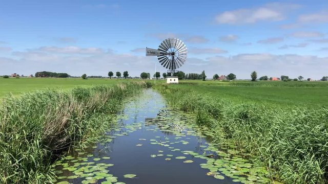 Canal and windmill around the village Boazum in Friesland The Netherlands