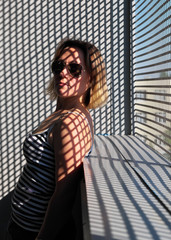 Portrait of a girl in glasses with a pattern of shadows.