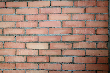 Big unfinished structure made of red blocks groomed by special equipment in order to plaster...