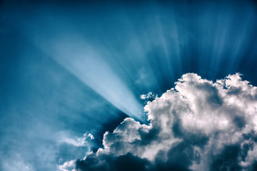 Cloud and sun rays on a background of blue sky.