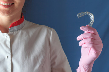 Female dentist holding mouth guard for teeth whitening