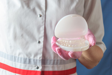 Female dentist holding a case with mouthguards for teeth whitening