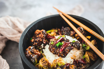 General Tso's Chicken with steamed rice and chopsticks 
