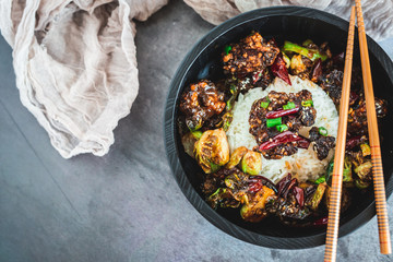 General Tso's Chicken with steamed rice and chopsticks 