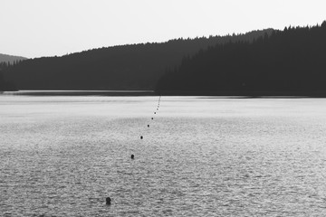 Leading line on the lake between mountains. Black and white