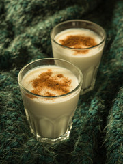 Eggnog. Traditional Christmas drink made from raw chicken eggs and milk with cinnamon in glass.