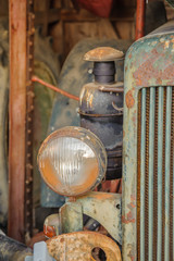 Fototapeta na wymiar Old rusty tractor in a barn under a plastic wrap