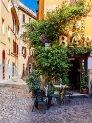 Fototapeta na wymiar Cozy old street in Trastevere in Rome, Italy. Trastevere is rione of Rome, on the west bank of the Tiber in Rome, Lazio, Italy. Architecture and landmark of Rome