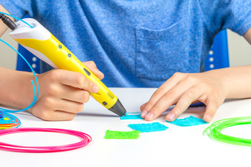 Kid hands creating with 3d printing pen new object