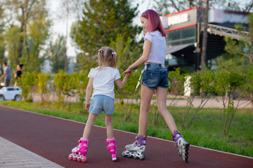 two girls on roller skates.two sisters rollerblading in the Park
