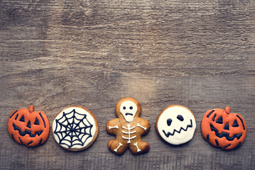 Halloween gingerbread cookies on wooden background.