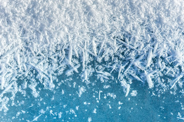 Winter background: close-up of frozen ice with snow crystals and snowflakes. Christmas and Happy New Year background with ice and snow texture