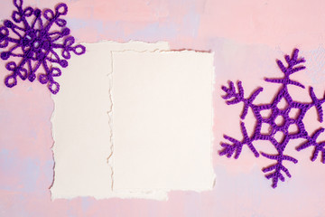 Christmas background with blank notebook, Blue crocheted snowflake, handmade on a purple-pink background. Mockup torn paper trend. Flat lay, top view. copy space.