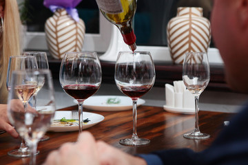 Red wine tasting in a restaurant. Photo without a face. Out of focus. Wine tasting concept in a restaurant or cafe.