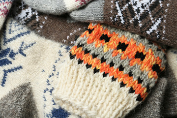 Different knitted woolen socks as background, closeup