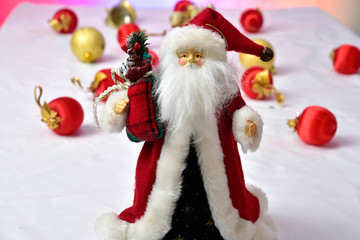 Santa Claus with colorful Christmas balls on the floor on white background