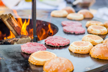 raw burger beef patties on the grill. Open fire on the barbecue