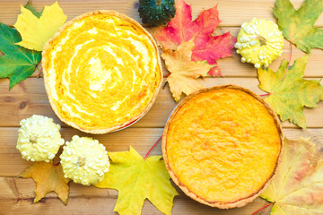 Festive wooden table with pumpkin pie and maple leaves. Happy thanksgiving day