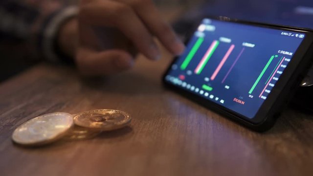 Real bitcoin coins on table. Block-chain, trading online, Cryptocurrency trend graph. Man touching screen, chart. Forex. Crypto currency. Bitcoin cryptocurrency. Candle graph. investment