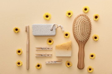 top view of wooden clothespins, toothbrush, hairbrush, pumice stone and piece of soap on beige...