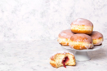 Traditional Polish donuts with frostng on light background. Tasty doughnuts with jam.