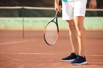 Fototapeta na wymiar Young man playing tennis on court