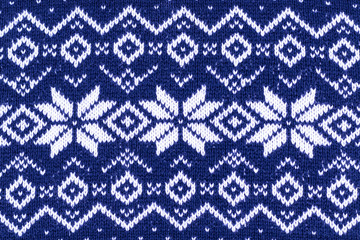 Warm Christmas blue sweater with snowflakes. Vintage Scandinavian Woolen Jumper Pattern. Closeup. Background. Knitting pattern with snowflakes.