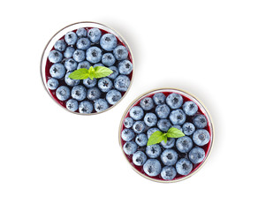 Glasses with blueberry dessert on white background