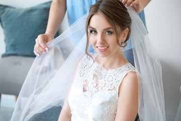 Professional hairdresser working with young bride at home