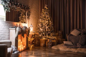 Stylish interior with beautiful Christmas tree and artificial fireplace at night