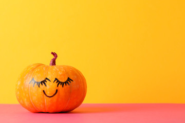 Pumpkin with smile against yellow background, space for text