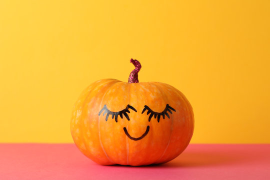 Pumpkin with smile against yellow background, space for text