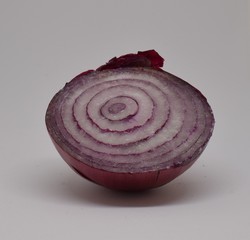 Fresh red onion cut horizontally, on white background.