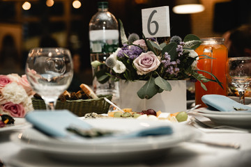 Beautiful  decorations of wedding table. Floral compositions on ceremony. Decorations made of wood with flowers and greenery. Rustic style. Close up