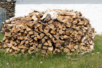 Woodpile of birch firewood stacked in a round pile and dried. Firewood for the winter. Energy and fuel for fire and heating.