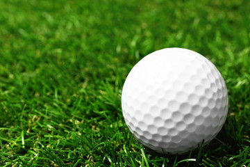 Golf ball on green course outdoors, closeup. Space for text