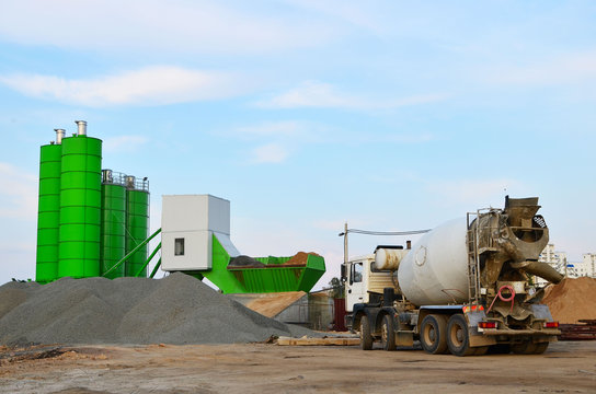 Concrete batching plant. Industrial producing concrete for construction. Heavy mixer concrete trucks waiting for to be loaded on the concrete factory - Image