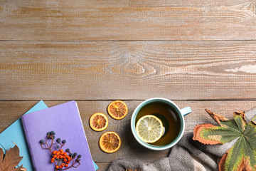 Flat lay composition with cup of hot drink on wooden table, space for text. Cozy autumn atmosphere
