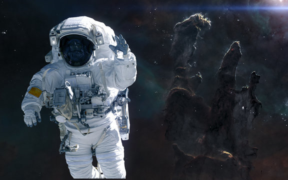 Astronaut on background of the Pillars of Creation. Science fiction. Elements of this image furnished by NASA